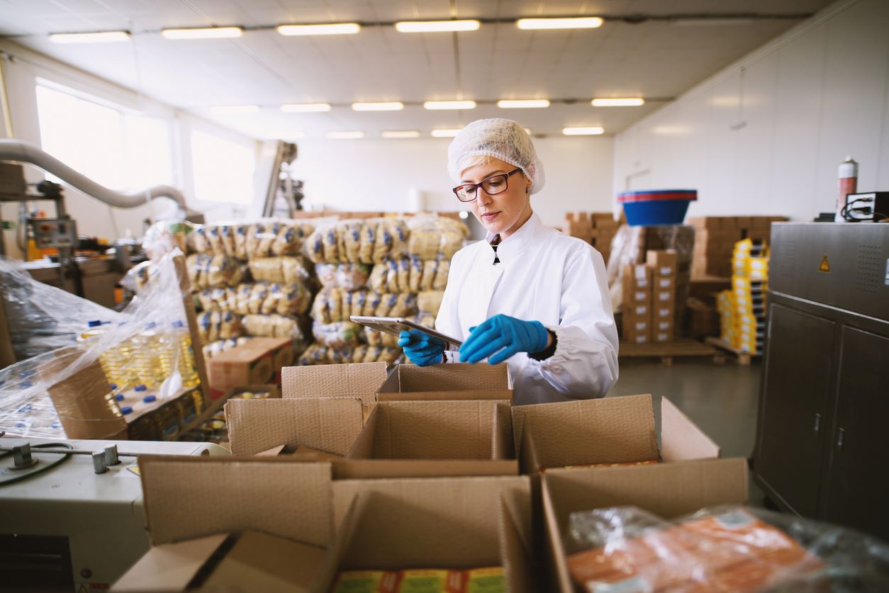 A woman in a sterile outfit inspects food deliveries for any warning signs about the products.