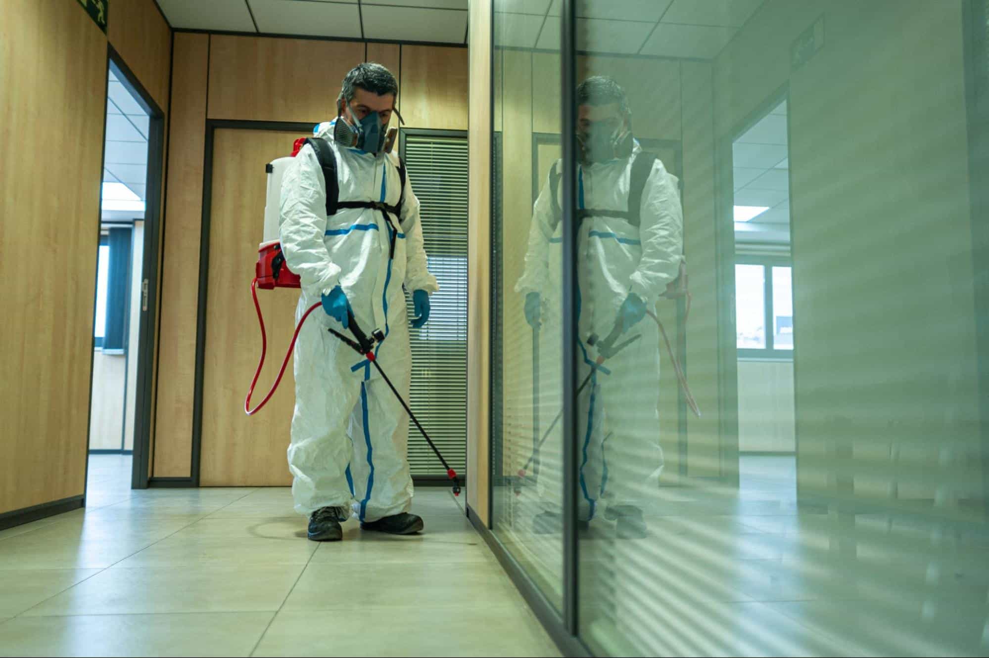 A pest control specialist at a business conducting a treatment.